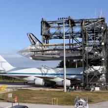 The Space Shuttle Discovery is lifted and ready to be placed on top of an aircraft designed to carry space shuttles.