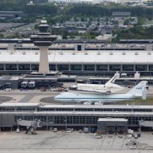 Space Shuttle Discovery, attached to an aircraft modified for shuttle transport, taxis on the runway at Washington Dulles International Airport.