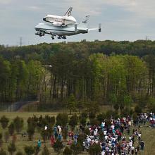 Space Shuttle Discovery flies low over crowd