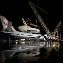 The Space Shuttle Discovery is prepared to be removed from the modified Boeing 747 used to transport the shuttle to the Udvar-Hazy Center.