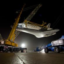 The Space Shuttle Discovery is lifted on a crane following its deattachment from the modified Boeing 747 used for shuttle transport.