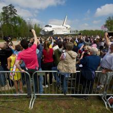 Spectators watch as the Space Shuttle Discovery is rolled towards the Udvar-Hazy Center.