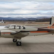 Side view of tan aircraft with orange and brown accent colors and two engines. Registration number N261B is painted in orange on the vertical stabilizer.