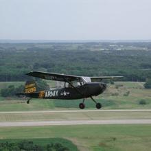 Side view of a gray monoplane in flight. White and yellow markings mark the plane as having belonged to the U.S. Army. The registration number 22196 is painted in yellow on the visible side of the vertical stabilizer.