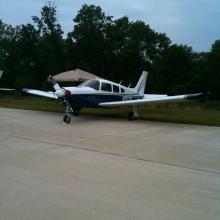 Frontal side view of a white and blue airplane with one propellor attached to the nose.