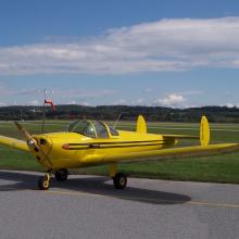 Side view of yellow monoplane with single engine.