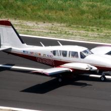 Side view of white and red monoplane with twin engines.