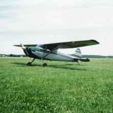 Side view of white monoplane with single engine.