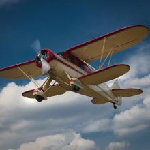 Bottom view of red and tan biplane with one engine.