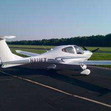 Side view of white monoplane with single engine. Behind the cockpit the registration number "N811ET" is painted in black.