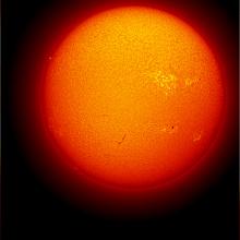 Disk view of the Sun's chromosphere with multiple sunspots visible on the surface of the Sun.