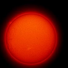 Disk view of the sun with a large prominence of floating gases on the upper right quadrant of the disk and a phage highlighted in yellow in the bottom center half.