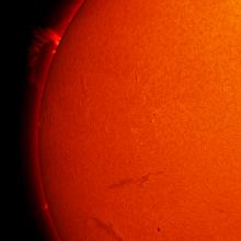 Partial disk view of the Sun's chromosphere, which focuses on one prominence rising from the Sun's surface.