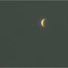 Venus as a waxing crescent shape seen during daytime hours.