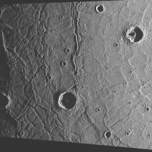 A view of topography on Mercury, featuring a basin on the left side and another set of trophs on the right side.