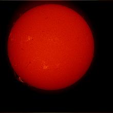 Disk view of the Sun featuring a prominence of floating gas above the lower half of the Sun. Phages are indicated by lighter colors and are visible mostly on the left half.