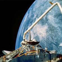 A view of the Hubble Space Telescope's payload bay and Canadarm with the backdrop of Earth.