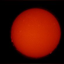 Disk view of the Sun's chromosphere with many prominences of floating gas visible on the far left and right edges of the disk, but little magnetic activity visible elsewhere.