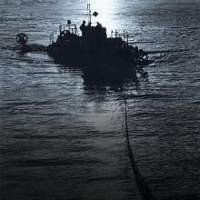 A silhouette of a boat being towed during nighttime hours