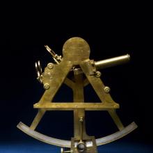 Gold-colored navigational tool shaped similar to a sector of a circle.