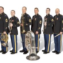 A group of six people holding various brass instruments.