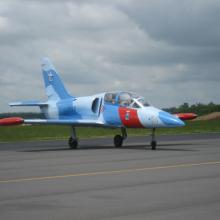 Side view of a blue and white monoplane with red accents. The single engine is not visible from this view.