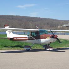 Side view of white and brown monoplane with single engine and fixed landing gear.