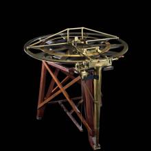 A navigation tool with a circular top and a three-legged base.