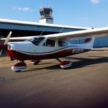 Side view of white and red monoplane with single engine and fixed landing gear. Registration number "N13019" is painted in red between the fuselage and vertical stabilizer.