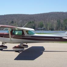 Red and white monoplane with single engine and fixed landing gear.