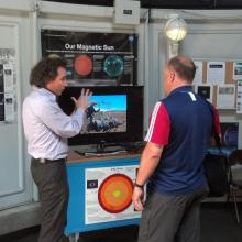 A visitor chats with a museum expert on astronomy inside the museum's observatory.