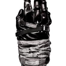 Black and white-colored, top-facing view of rubber glove intended for use on an Apollo mission.