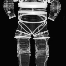 Negative x-ray of the front view of an early, experimental full-body spacesuit. Full flexibility can be seen in joint regions through the spring-like appearance of white lines around joints.