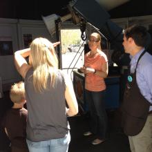 Museum visitors speak with a museum astronomy expert inside the Museum's observatory.