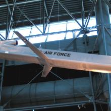 Silver-colored metallic missile with small set of center wings displayed in the Museum.