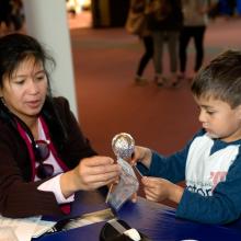 Two museum visitors participate in a craft activity at the museum.