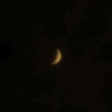 View of Venus in a crescent phase during daytime hours.