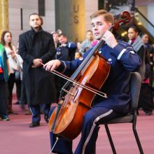 A cellist in U.S. Air Force uniform plays during a surprise performance at the Museum.