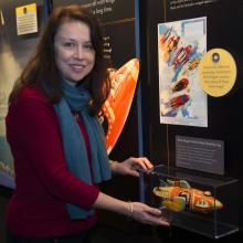 Margaret Weitekamp, the Museum's Curator of Space History, stands in front of an exhibit about space.