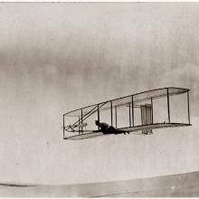 Man soars a few feet above the ground in a glider