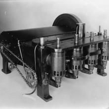 A dark colored box-shaped engine with four cast iron cylinders and an aluminum case.