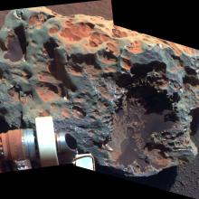 A large meteorite found and tested on Mars by Opportunity Rover, whose arm is visible in the view of the meteorite.