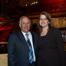 George and Nina Cois, a couple consisting of a white male and a white female, pose together at a reception.