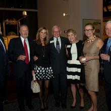 A group of people stand together at a reception held at the Museum.