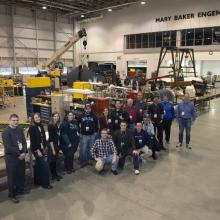 Museum staff and volunteers pose with ten social media participants inside the Restoration Hangar at the Steven F. Udvar-Hazy Center.