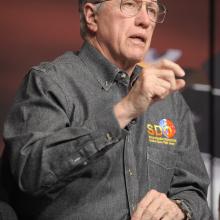 Richard Fisher, a white man, speaks during a briefing.