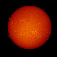 Disk view of the Sun's atmosphere. Floating gases off the edge of the disk called prominences are visible as well as filaments (dark lines) on the disk of the Sun. Sunspots (dark spots) and phages (lighter-colored clouds) are also visible on the disk.