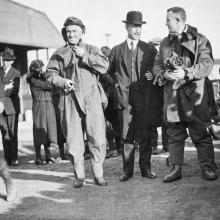 John Macready and Oakley Kelly stand with Orville Wright following an air race which Macready and Kelly participated in. All three are white men.