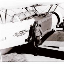 Roy Geiger, a white male pilot, stands next to an aircraft wearing aviator gear.