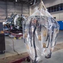 A part of the ignition system of a military aircraft is hanging above the ground in a plastic layer.